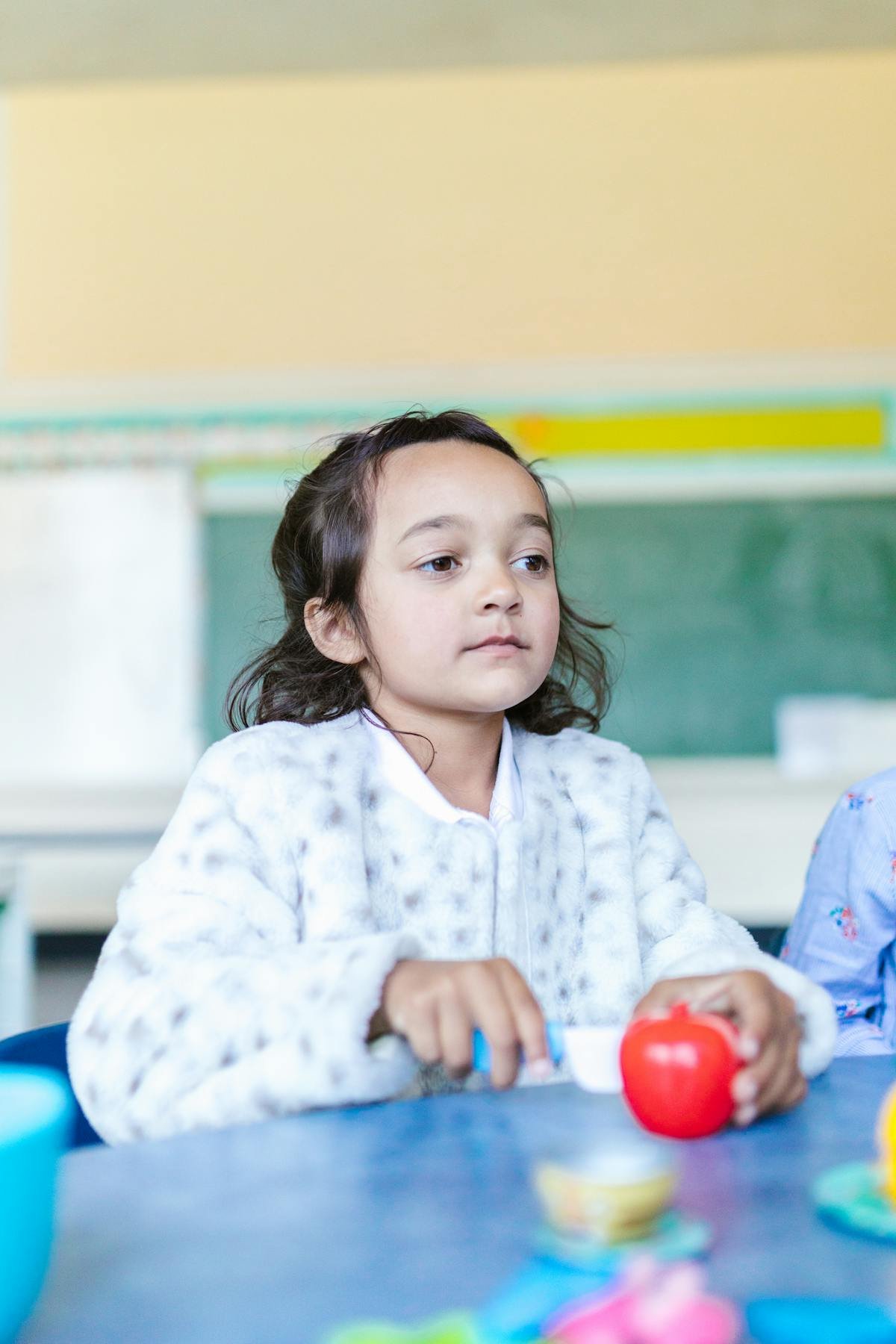 A young child engaged in nursery school, curious and capable