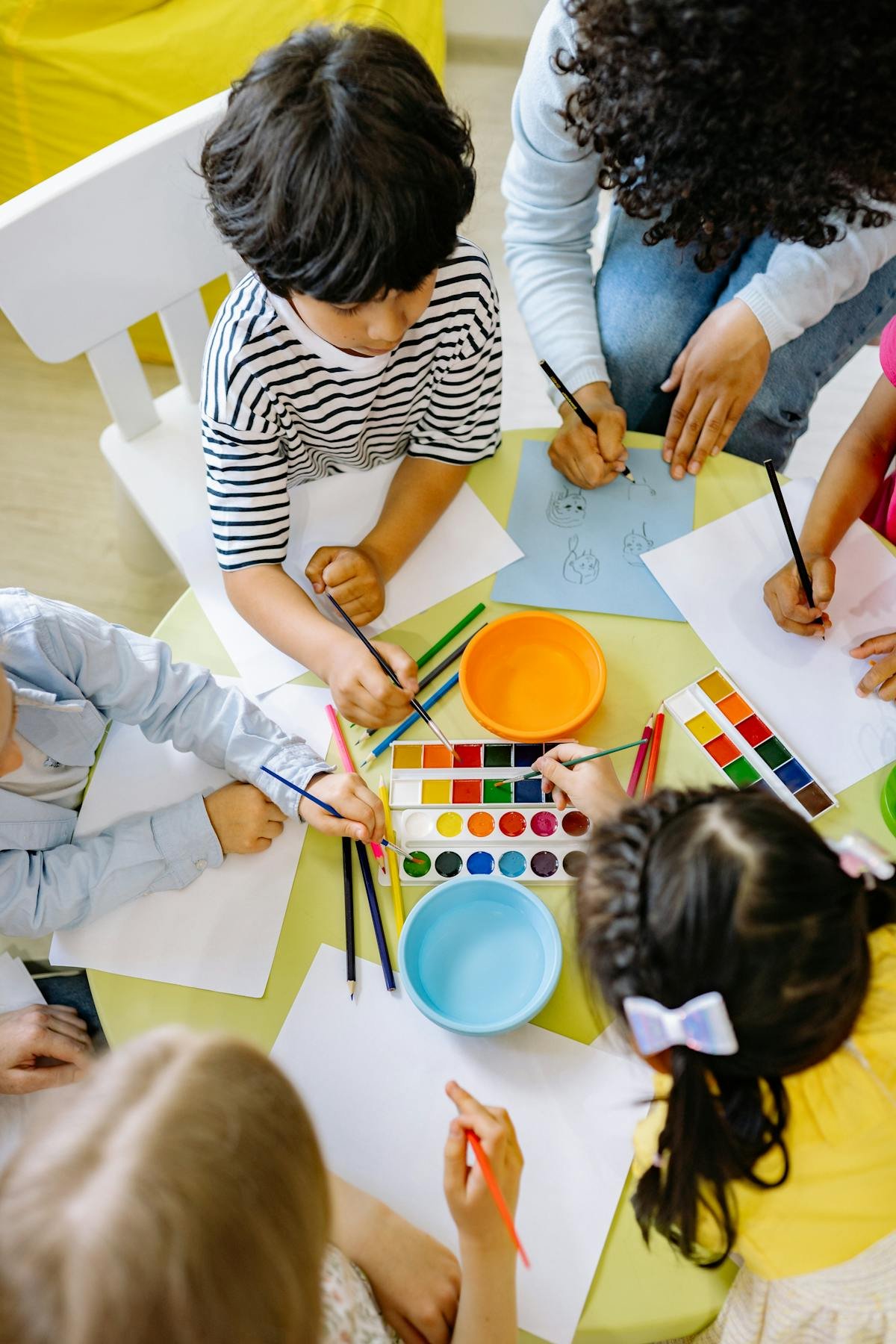 Preschool children painting with watercolors, hands-on creative learning at Give Me A Break